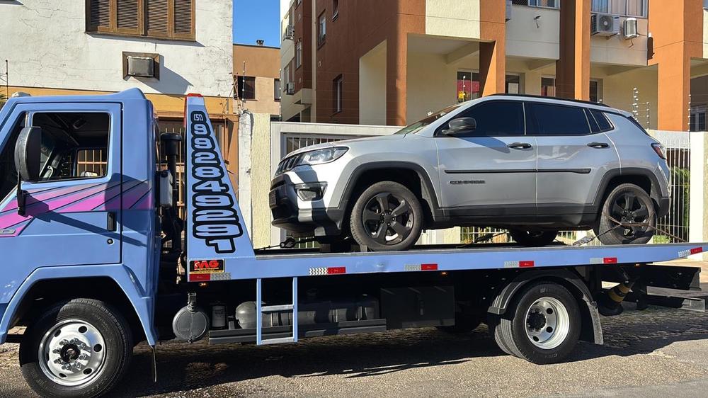 SUV prata sobre a plataforma do guincho